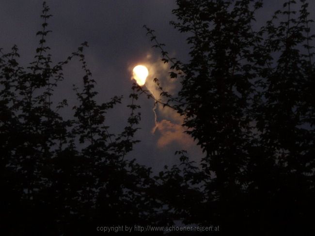 Der Mond zeigt sich kurz hinter mächtigen Wolken